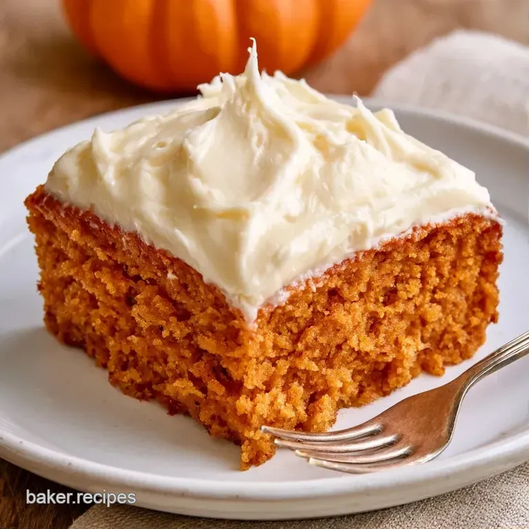 Golden-orange cake slice on a white porcelain plate, paired with a swirl of cream and a dusting of nutmeg.